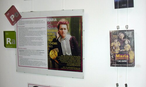 Duża plansza o tematyce Marii Curie-Skłodowiskiej. Po prawej stronie książki na jej temat.
